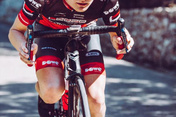 Rennrad-Athlet von Leeze mit DOWE Trikot und Hose