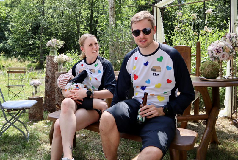 Ein Paar mit Bike-jerseys und Kind im Garten